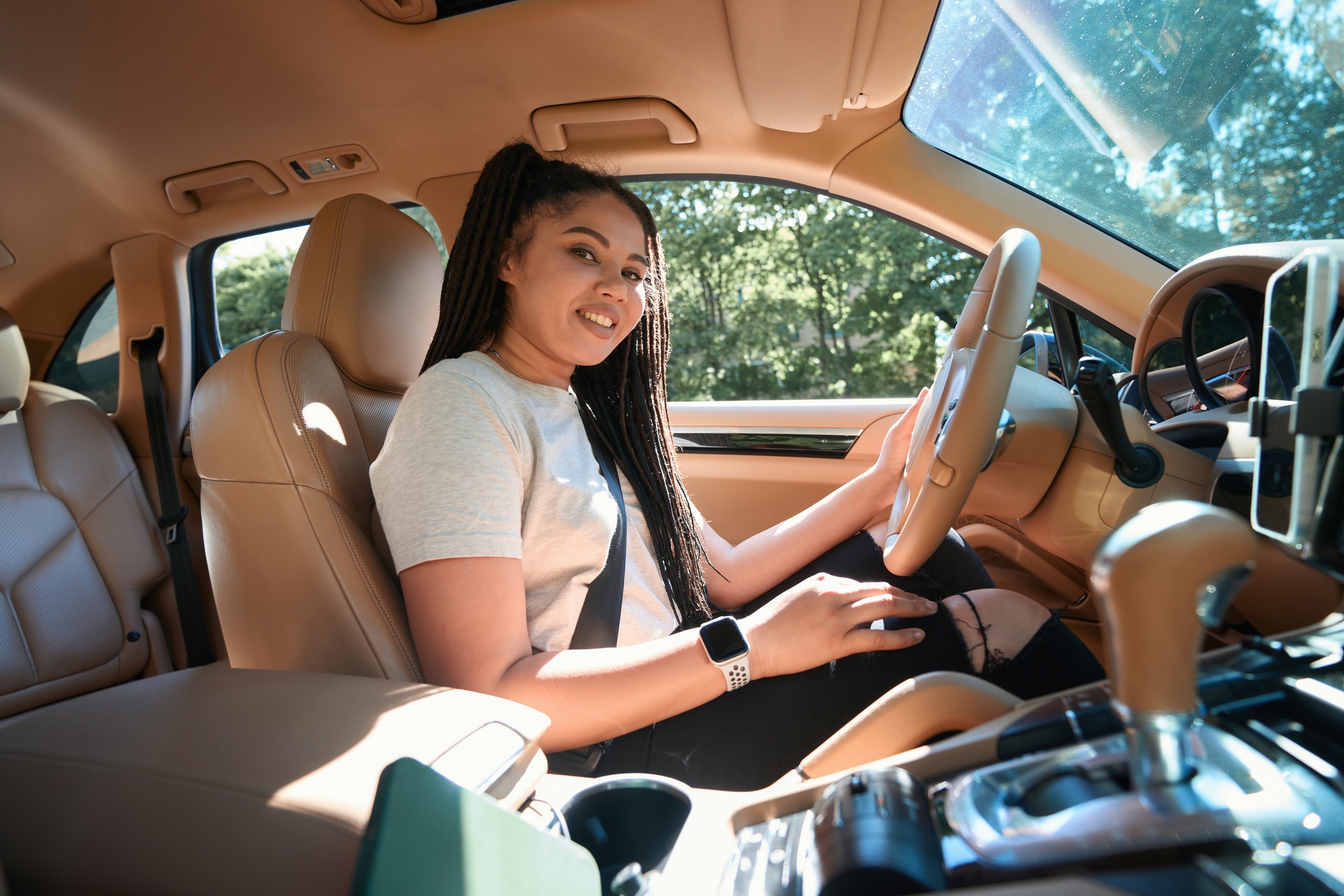 Cheerful automobile driver seated at steering wheel