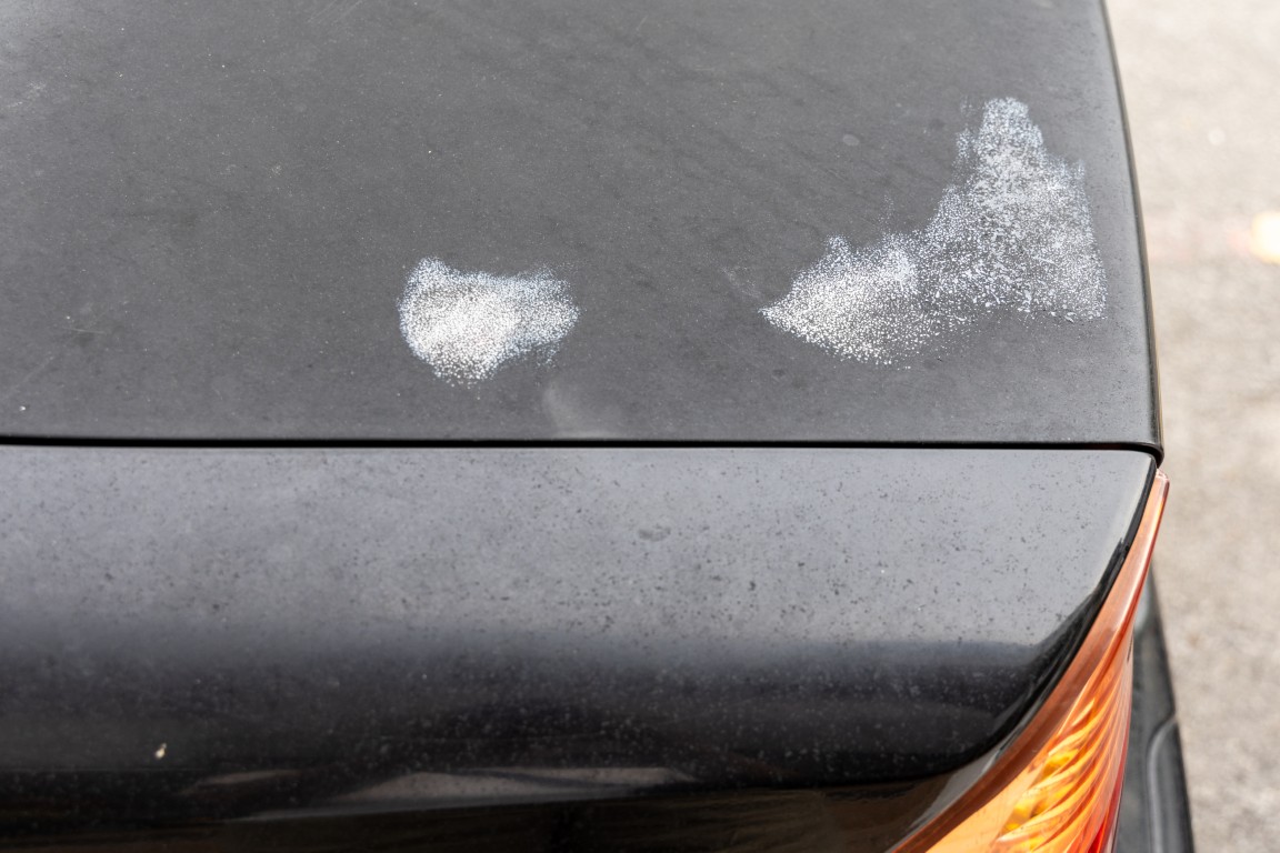 Car bonnet with patch of corroded paint due to exposure to intense weather heat and possibly neglect.