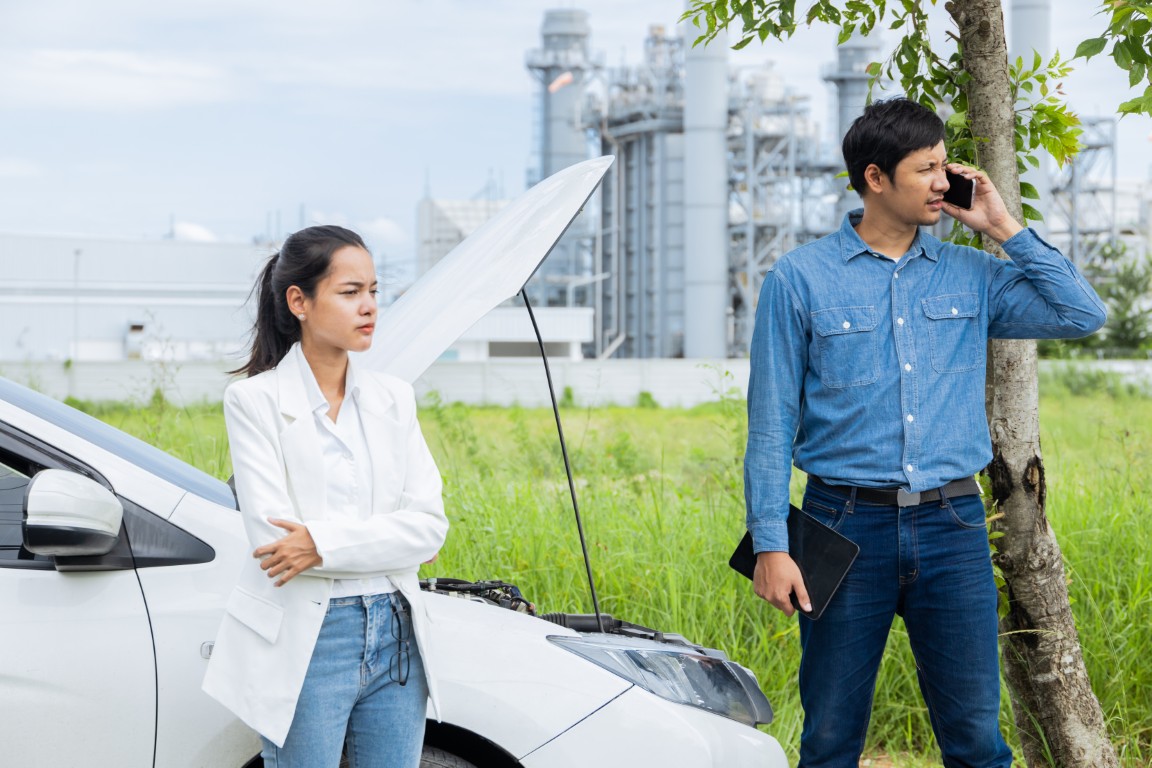 Women Car Broken on the Road. Young Couple Inspecting Car Engine on a Scenic Roadside